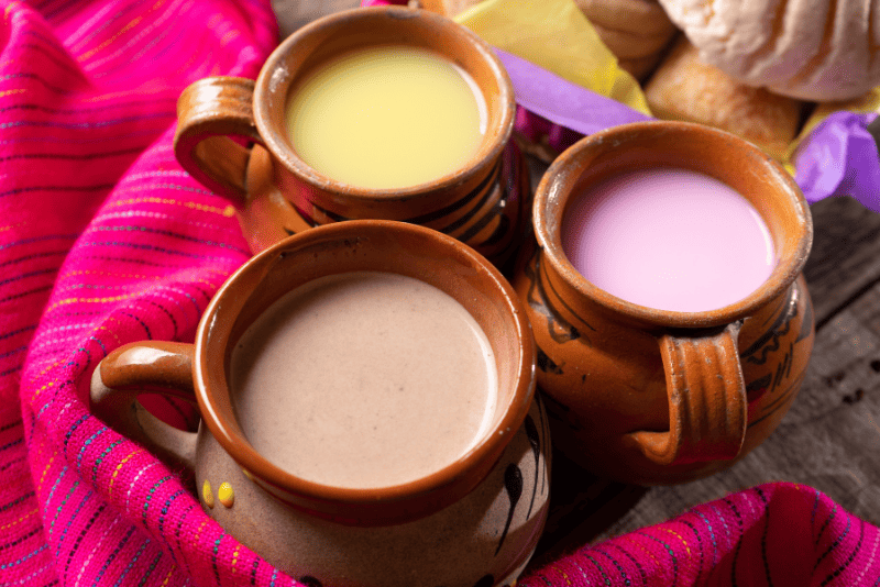 Taza de atole espeso y caliente con canela, ideal para el desayuno.