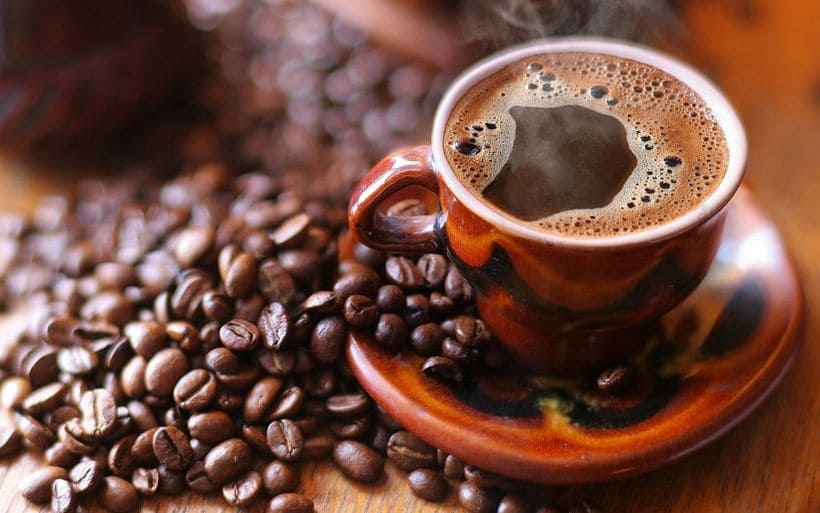 Taza de café de olla con canela y piloncillo, servido en una taza de barro.